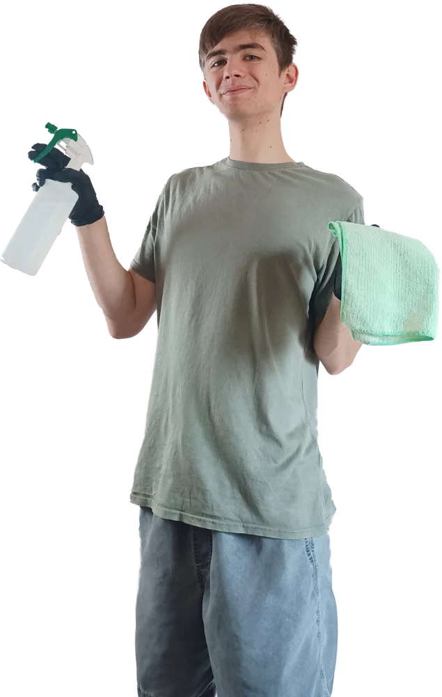 Charles, smiling, holding a chemical spray bottle and a cloth.